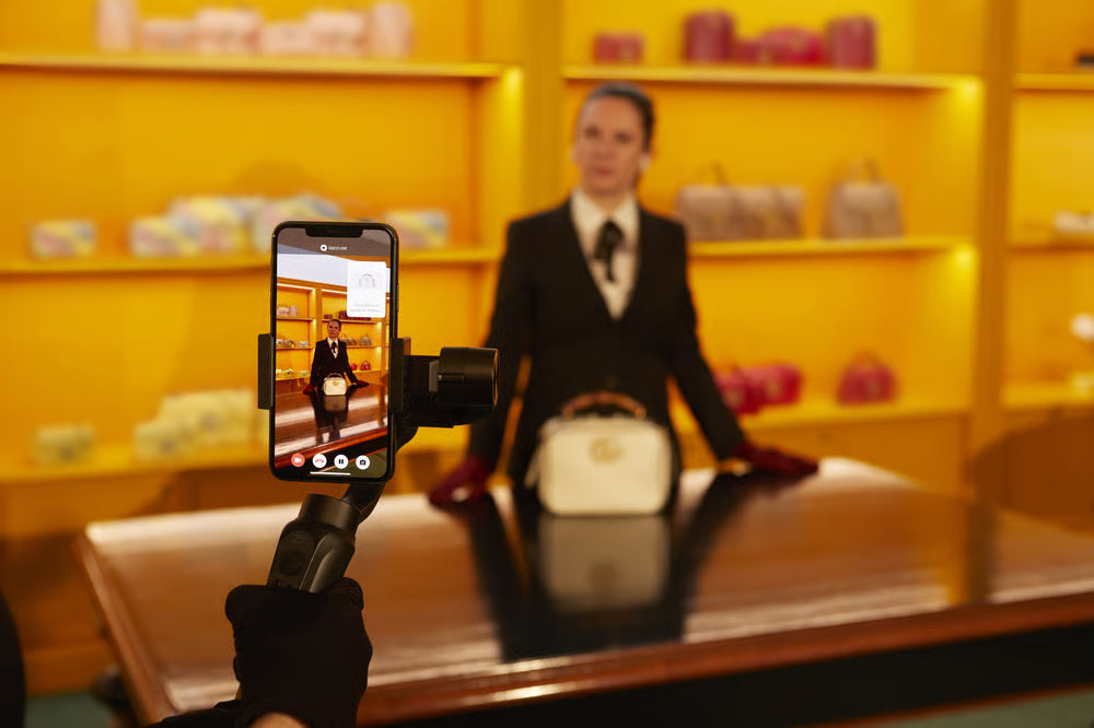 Vente aux enchères en direct sur Whatnot : présentation d'un sac de luxe filmée au smartphone